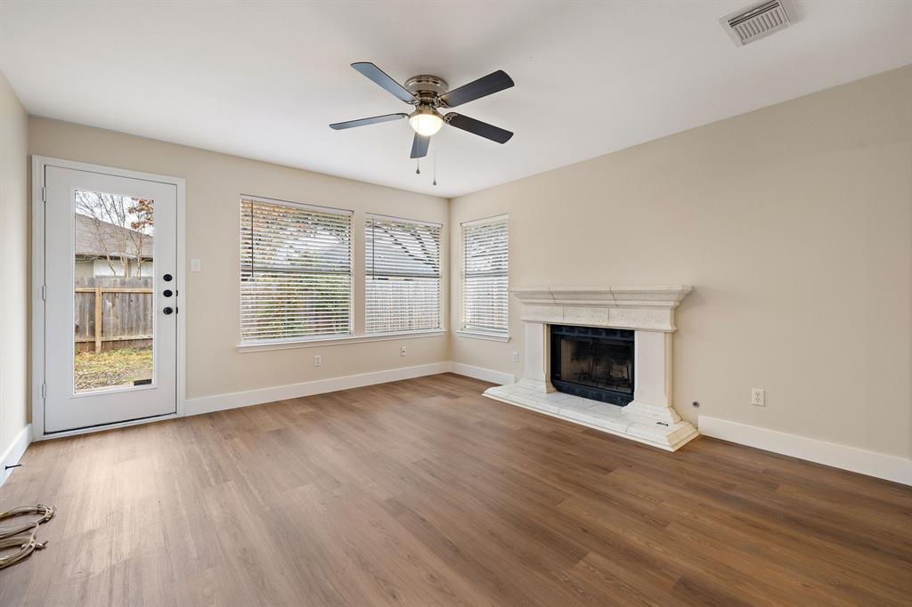 13412 Tossa Lane Austin, TX 78729 - Photo 15 of 16 an empty room with wooden floor a ceiling fan and windows