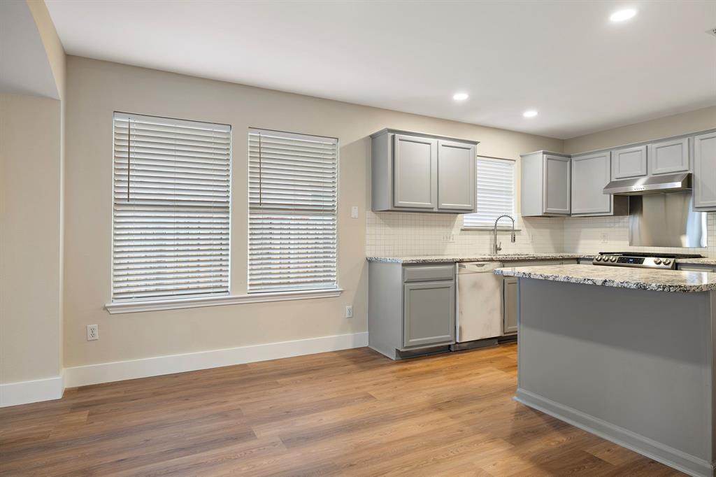 13412 Tossa Lane Austin, TX 78729 - Photo 2 of 16 a kitchen with granite countertop a stove a sink and a microwave