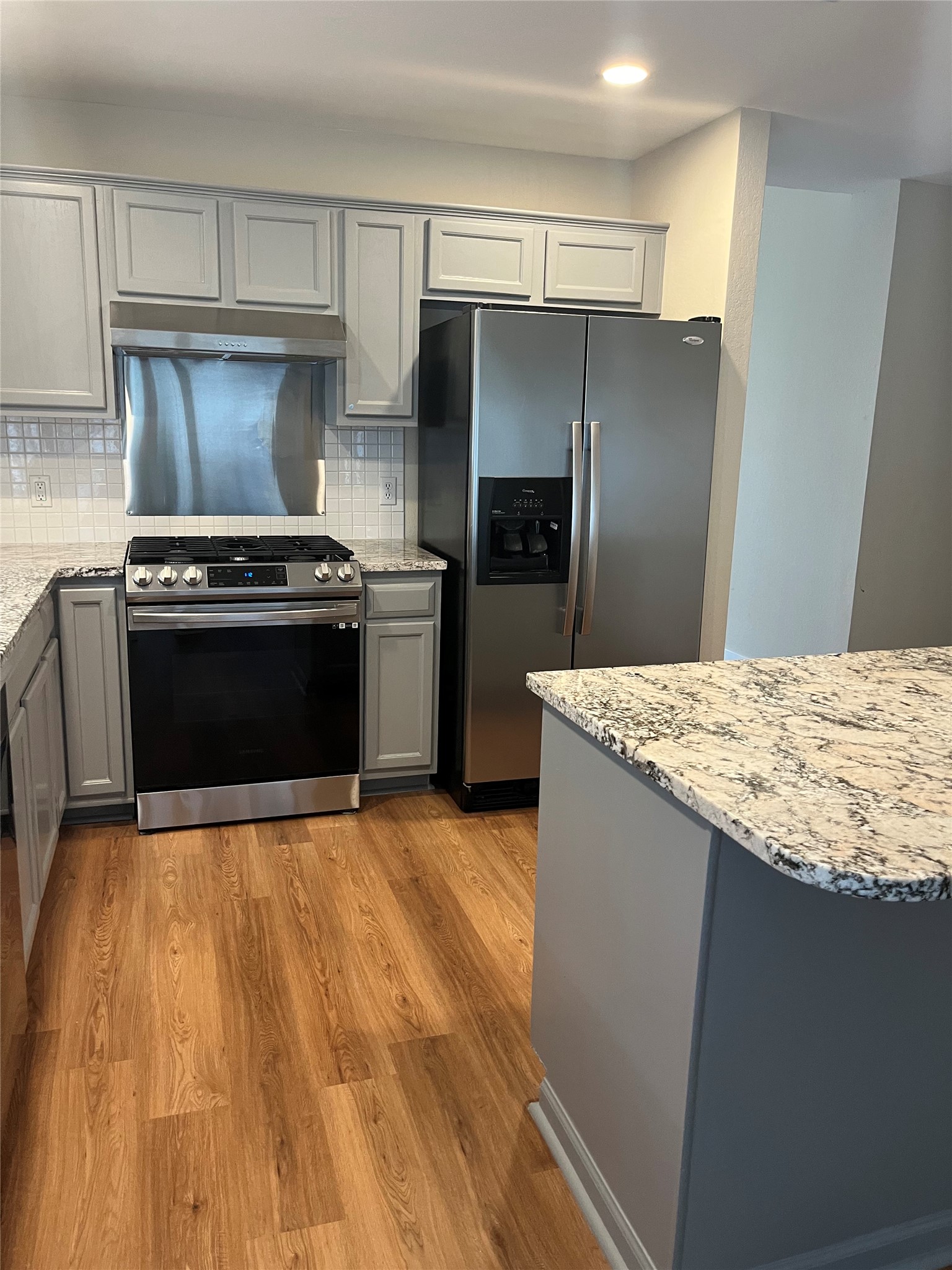 13412 Tossa Lane Austin, TX 78729 - Photo 3 of 16 a kitchen with granite countertop a stove and a refrigerator