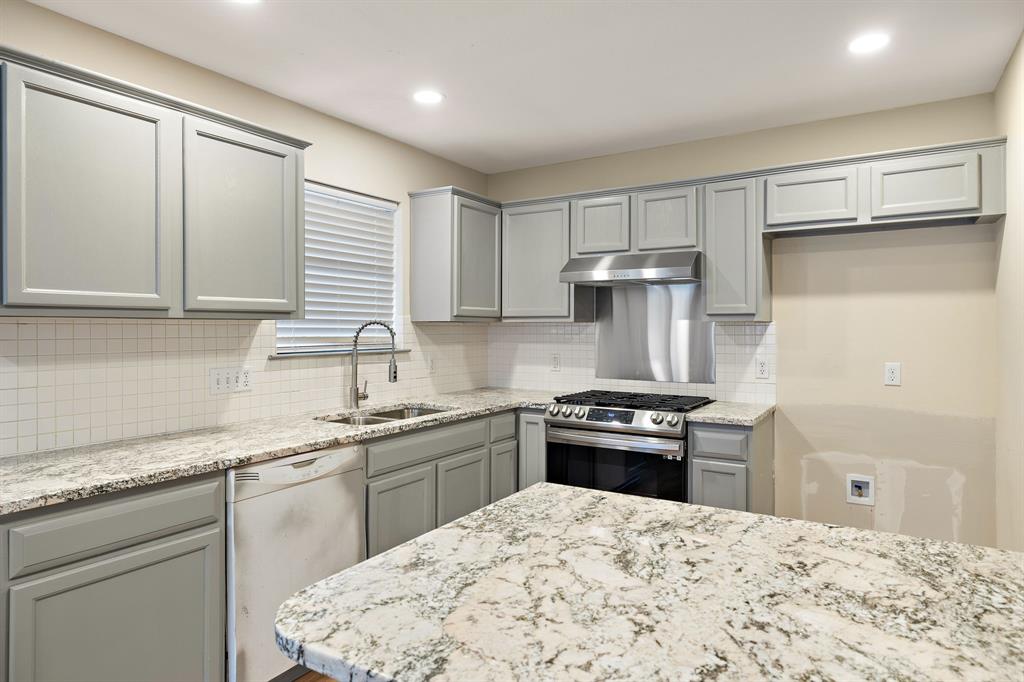 13412 Tossa Lane Austin, TX 78729 - Photo 4 of 16 a kitchen with stainless steel appliances granite countertop a sink stove and refrigerator