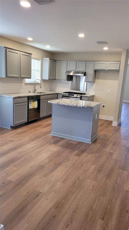 13412 Tossa Lane Austin, TX 78729 - Photo 6 of 16 a kitchen with stainless steel appliances granite countertop a stove a sink and a refrigerator