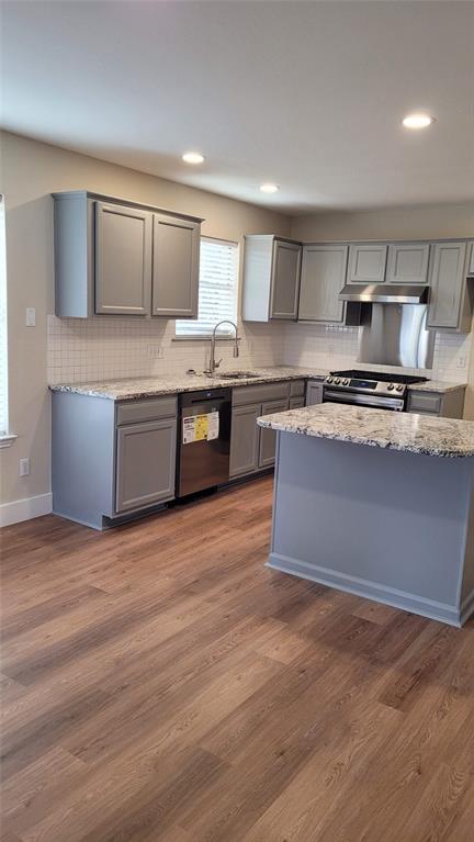 13412 Tossa Lane Austin, TX 78729 - Photo 7 of 16 a kitchen with stainless steel appliances granite countertop a stove a sink and a refrigerator