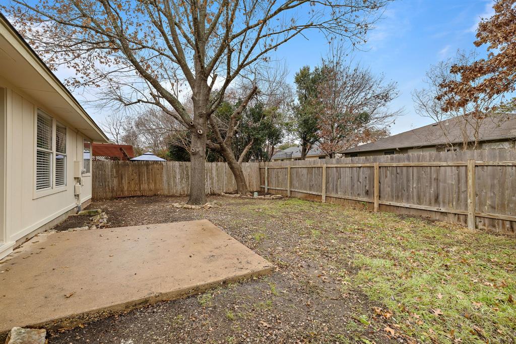 13412 Tossa Lane Austin, TX 78729 - Photo 10 of 16 a backyard with wooden fence and a large tree