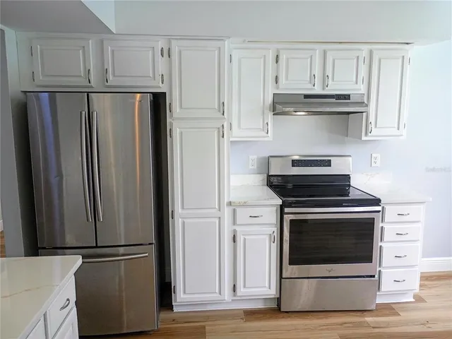 a kitchen with cabinets and stainless steel appliances