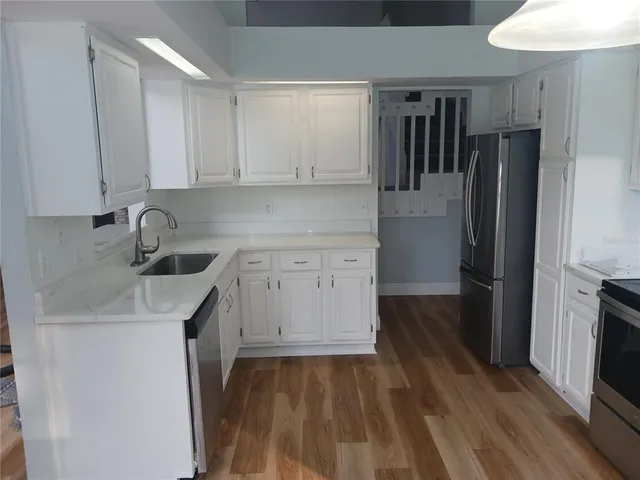 a kitchen with a sink a refrigerator and cabinets