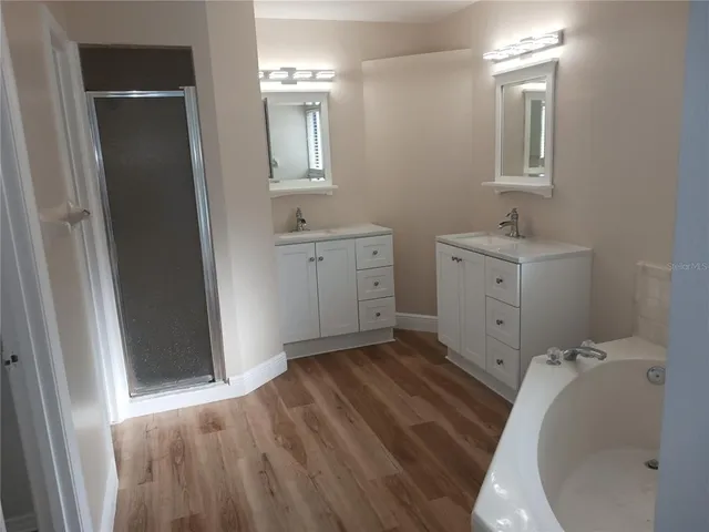 a bathroom with a sink and mirror with shower