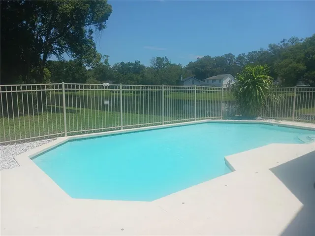 a view of a swimming pool with a lake from a balcony