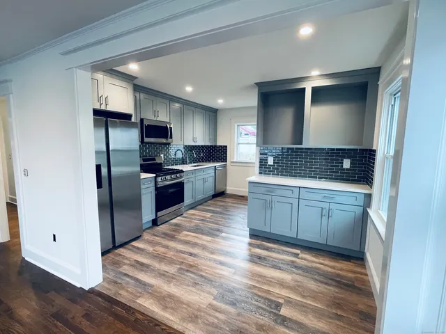 a kitchen with stainless steel appliances granite countertop a refrigerator and a stove top oven