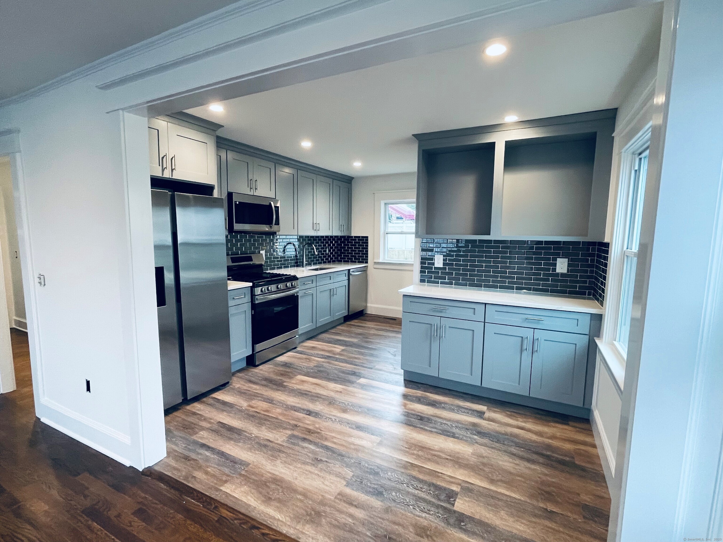 a kitchen with stainless steel appliances granite countertop a refrigerator and a stove top oven