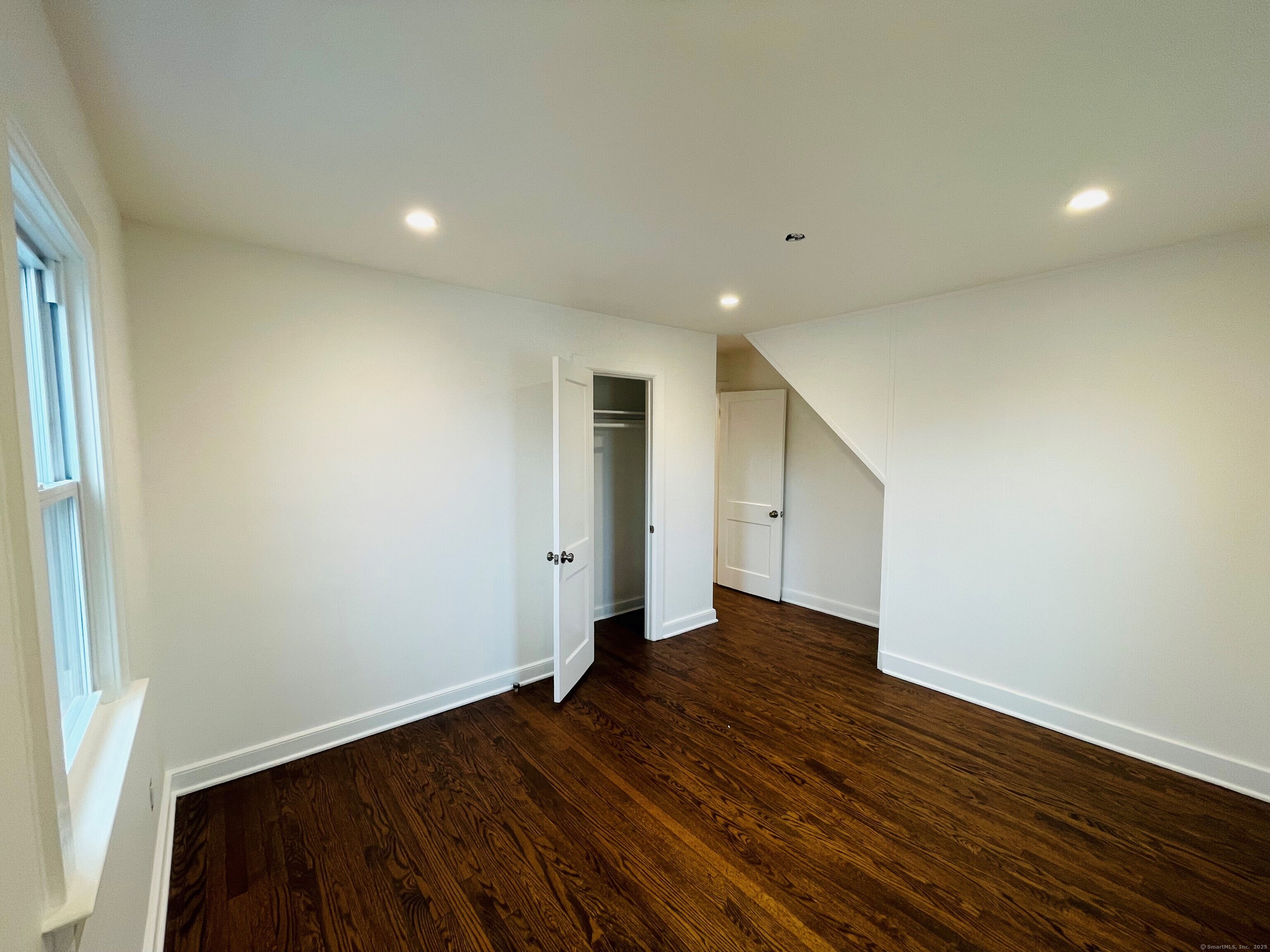 317 Strawberry Hill Avenue Norwalk, CT 06851 - Photo 16 of 30 an empty room with wooden floor and windows