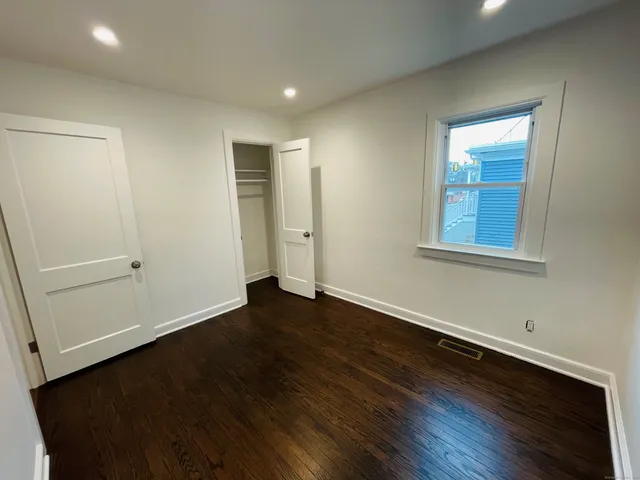 an empty room with wooden floor and closet