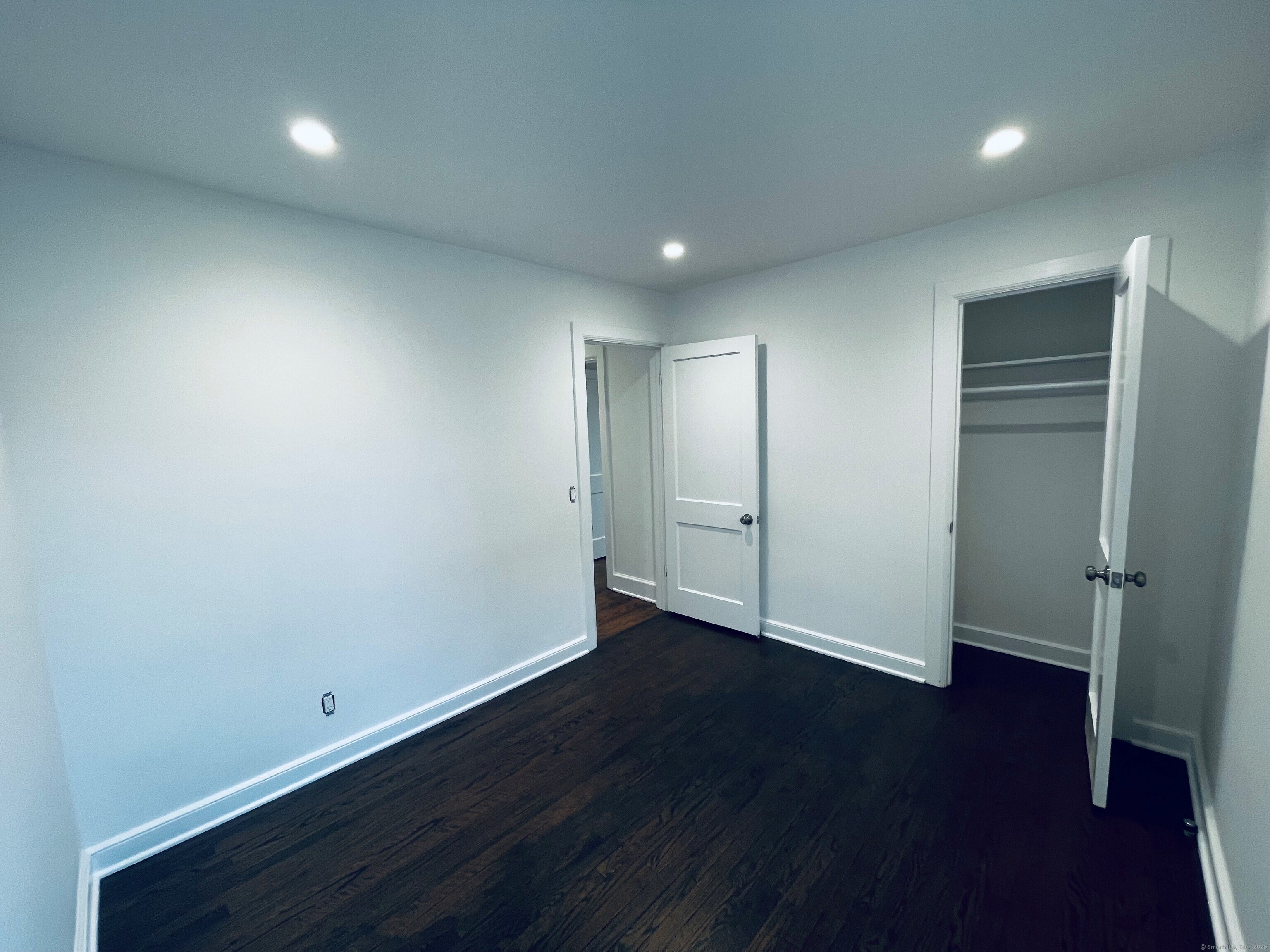 317 Strawberry Hill Avenue Norwalk, CT 06851 - Photo 18 of 30 an empty room with wooden floor and closet area