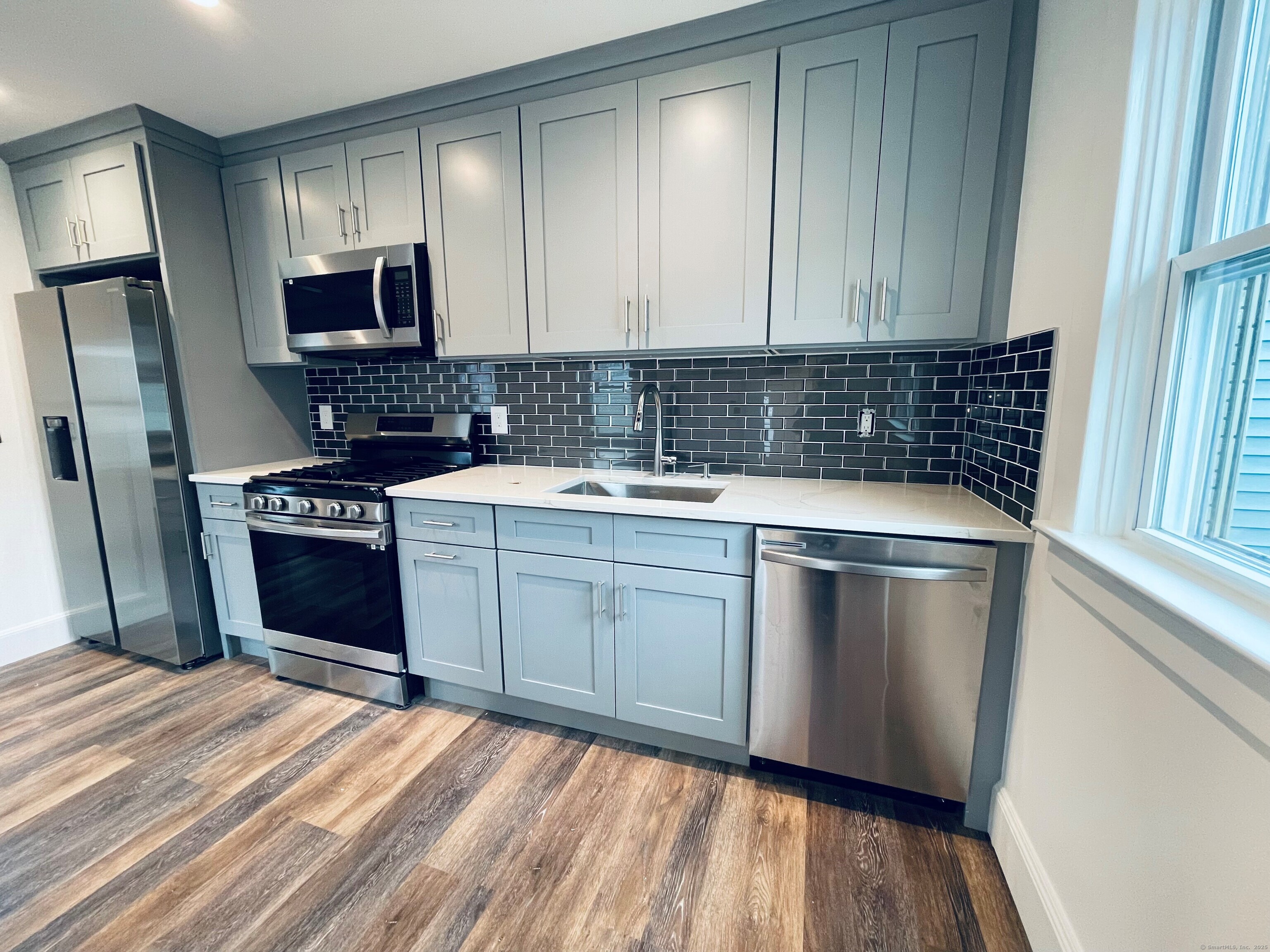 317 Strawberry Hill Avenue Norwalk, CT 06851 - Photo 2 of 30 a kitchen with a sink stove and refrigerator