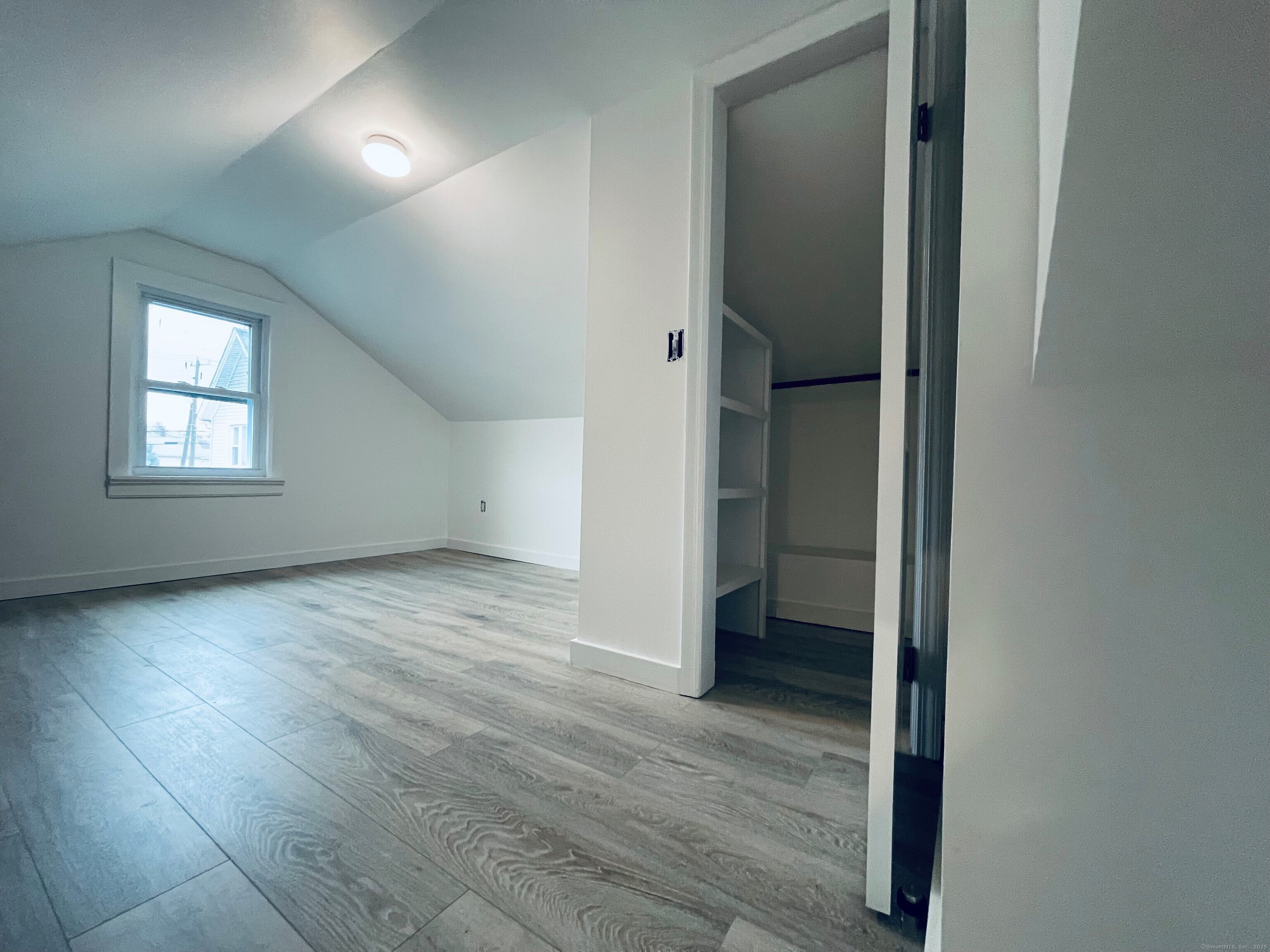 317 Strawberry Hill Avenue Norwalk, CT 06851 - Photo 28 of 30 an empty room with wooden floor and a window