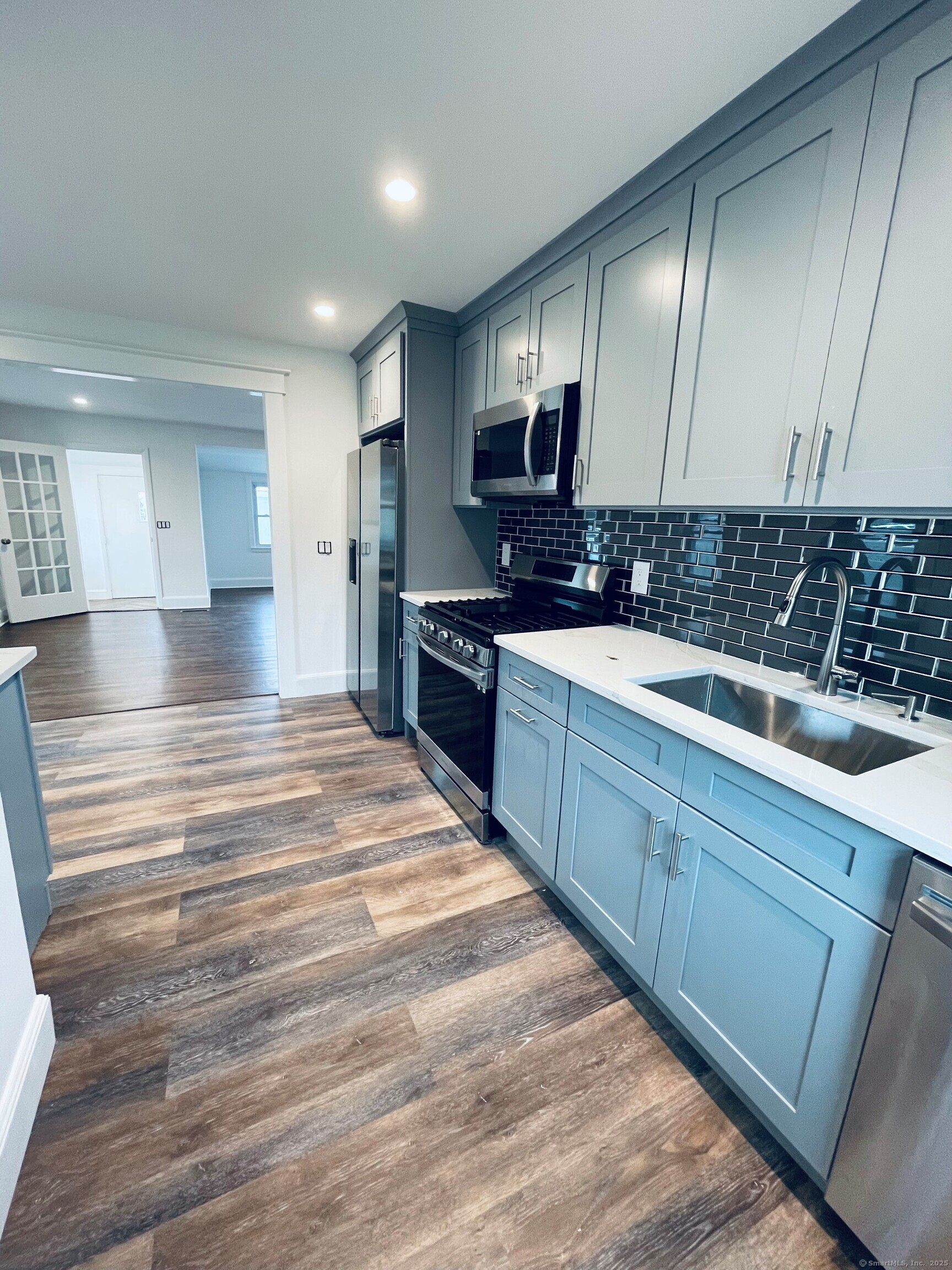 317 Strawberry Hill Avenue Norwalk, CT 06851 - Photo 3 of 30 a large kitchen with stainless steel appliances kitchen island granite countertop a sink and cabinets