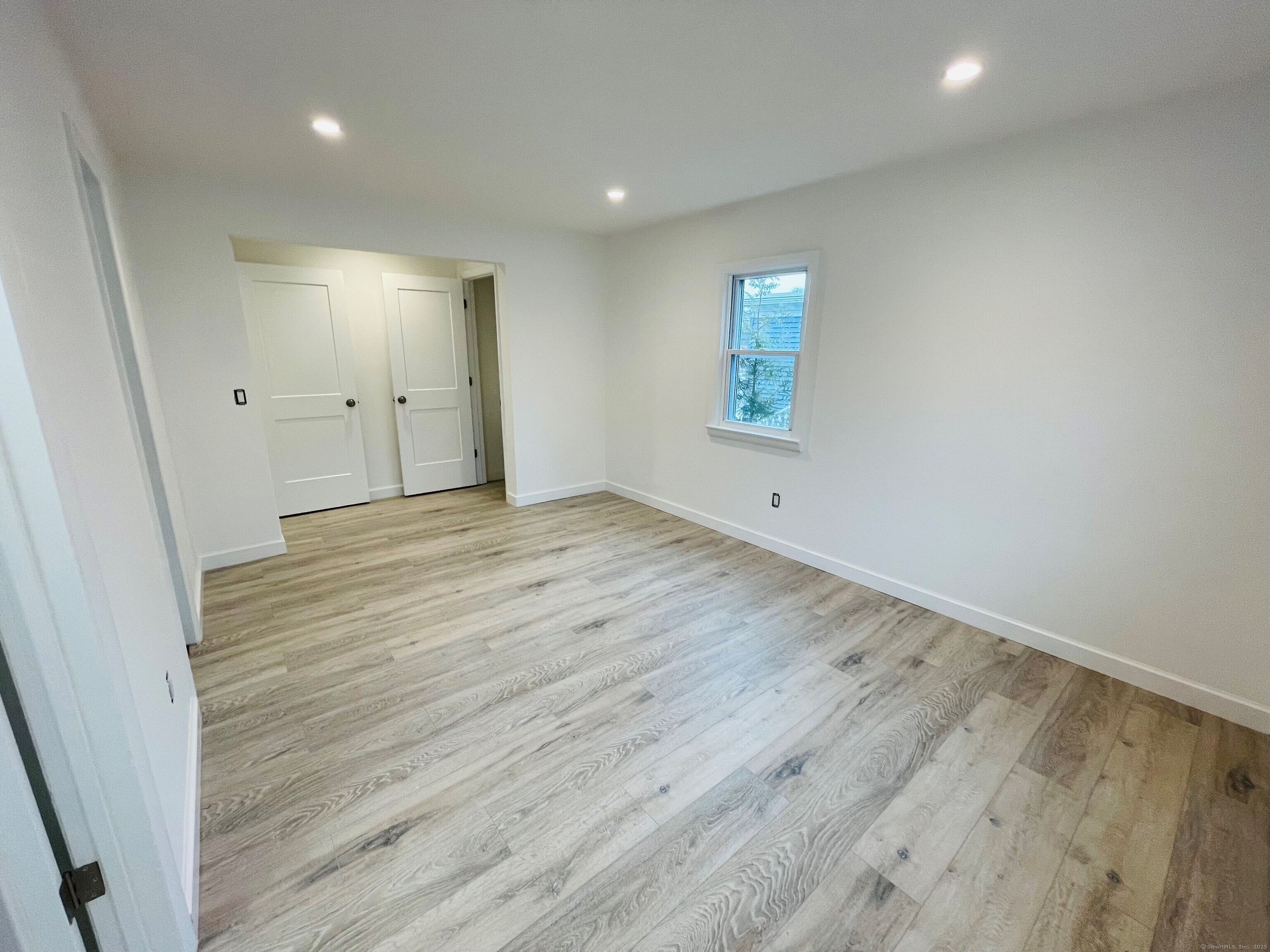 317 Strawberry Hill Avenue Norwalk, CT 06851 - Photo 8 of 30 an empty room with wooden floor and windows