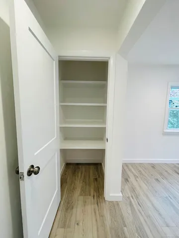 a view of a room with wooden floor and a ceiling fan