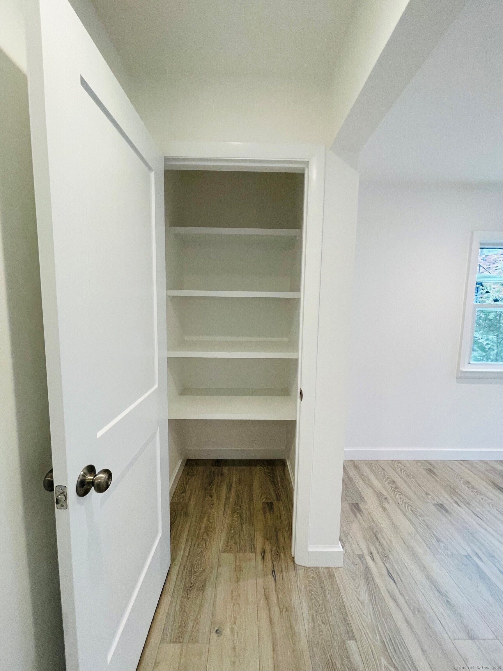 317 Strawberry Hill Avenue Norwalk, CT 06851 - Photo 10 of 30 a view of a room with wooden floor and a ceiling fan