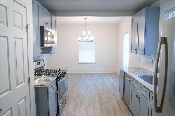 a kitchen with granite countertop a sink stove and refrigerator
