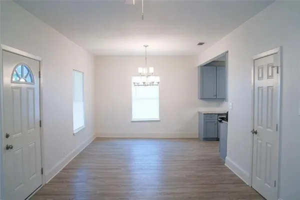 an empty room with wooden floor and a window