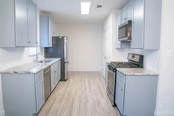 a kitchen with a sink stove and cabinets
