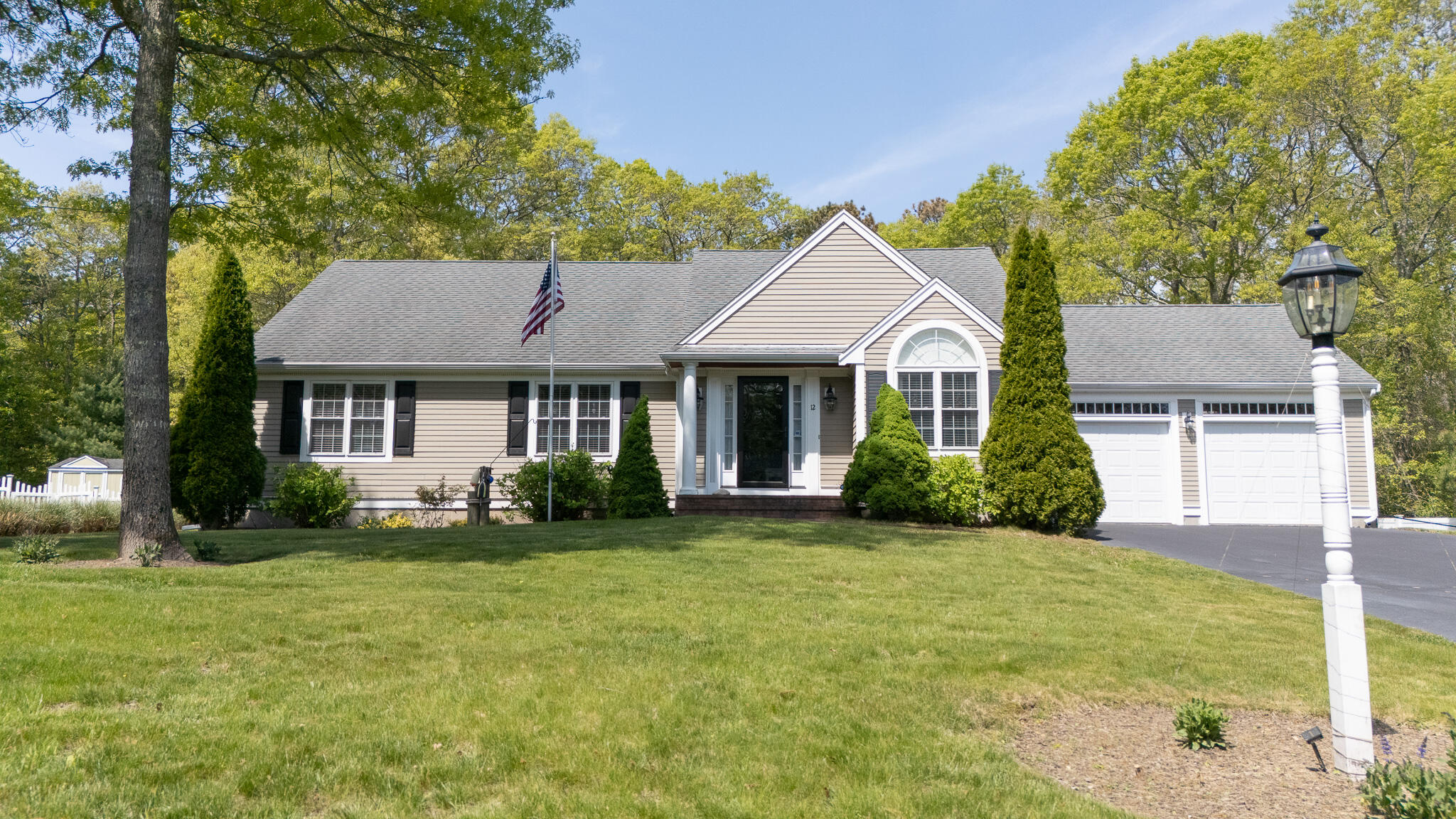 12 Sheffield Place Mashpee, MA 02649 - Photo 3 of 61 a front view of a house with a yard and trees