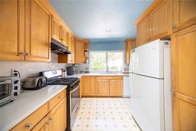 a kitchen with stainless steel appliances a refrigerator sink and cabinets