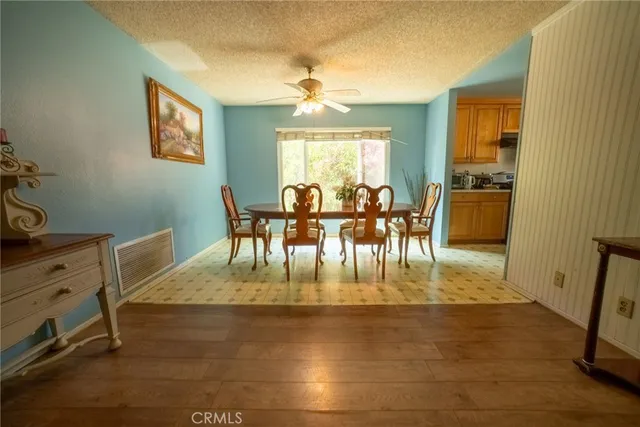 a view of dining room and livingroom with furniture wooden floor a rug and a chandelier