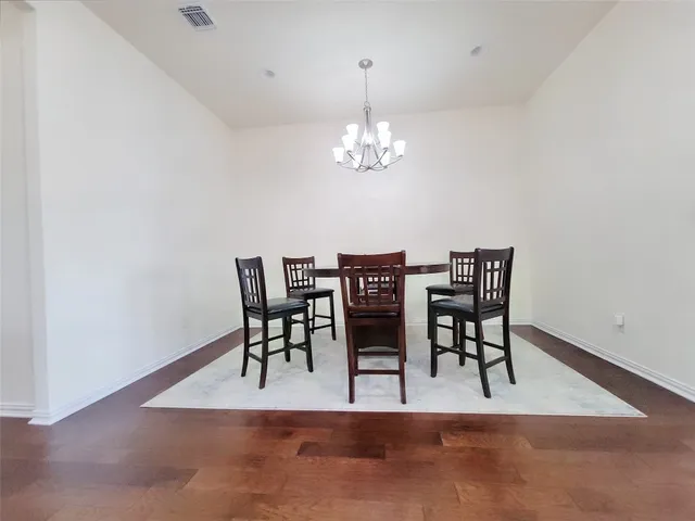 a view of a dining room with furniture and chandelier