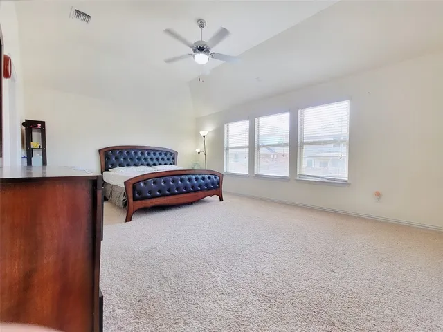 an empty room with windows and ceiling fan