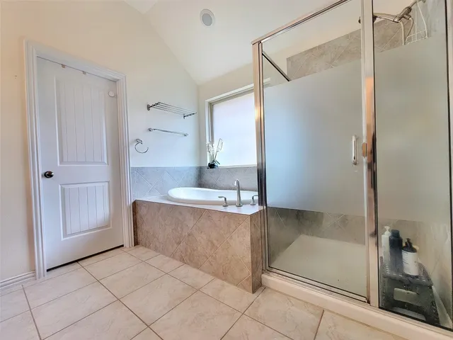 a spacious bathroom with a tub shower and mirror