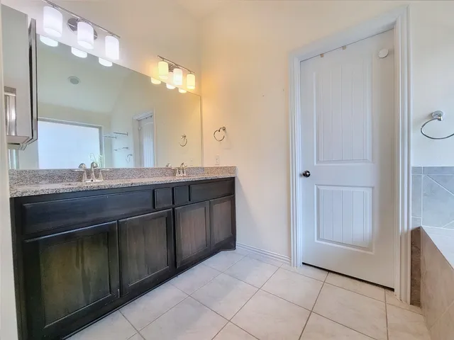 a bathroom with a granite countertop sink two mirror and a