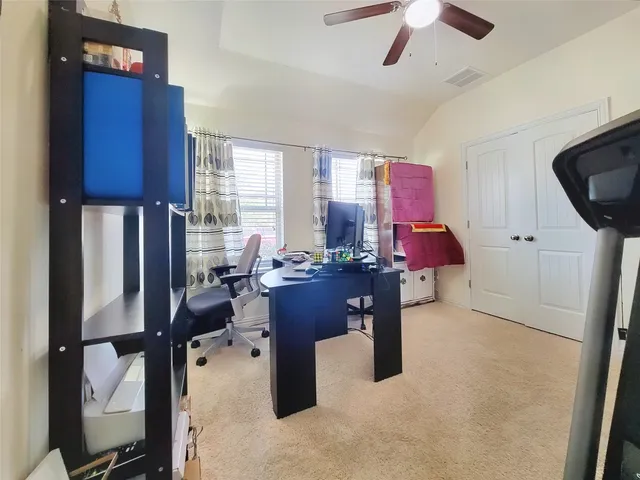 a view of a workspace with furniture and a window