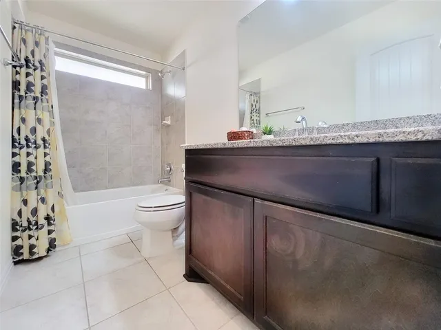 a bathroom with a granite countertop sink a toilet and shower