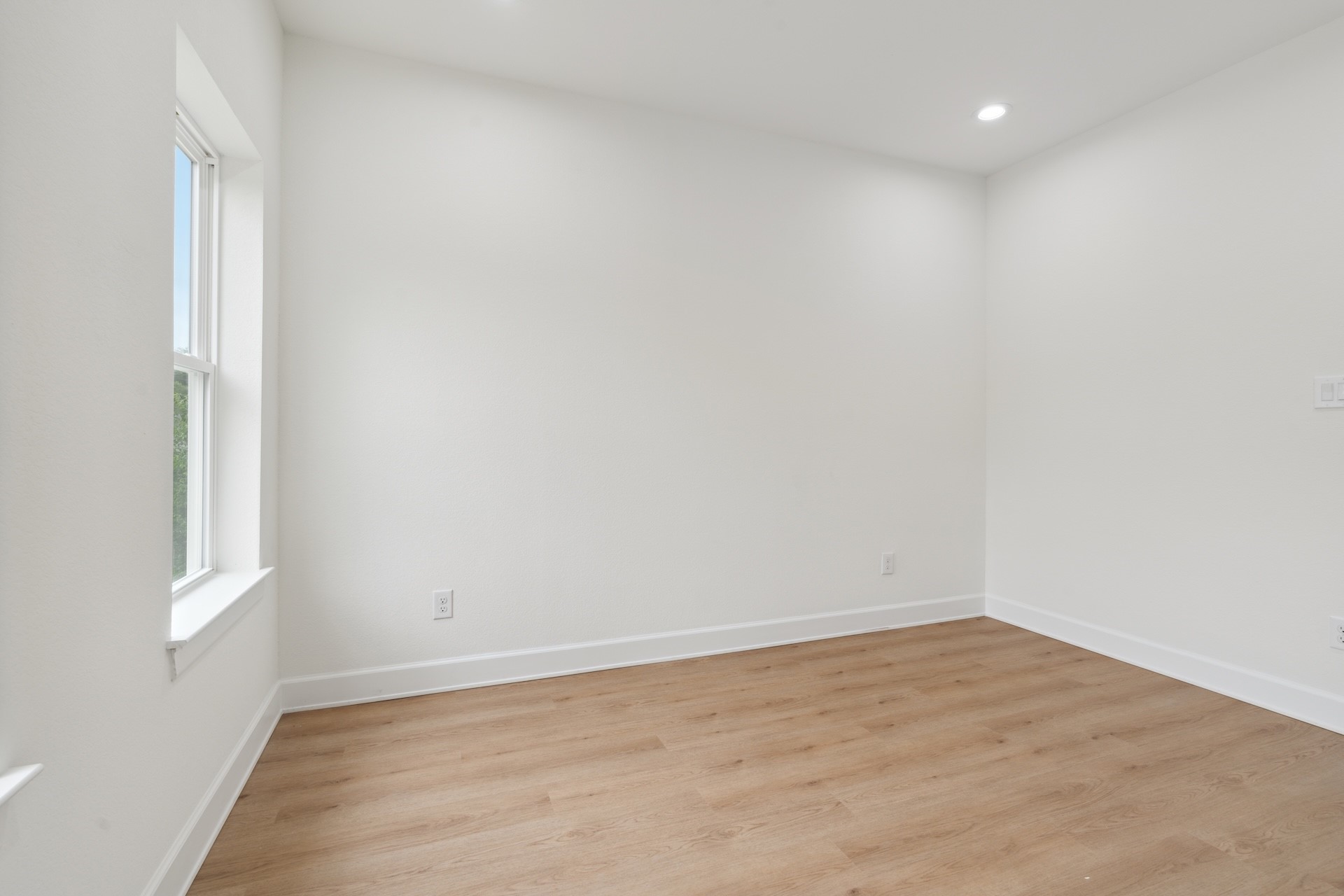 6408 Foster Street Houston, TX 77021 - Photo 20 of 39 Flexible office or bedroom space — soft wood-look flooring, bright window placement, and recessed LED ceiling lighting.