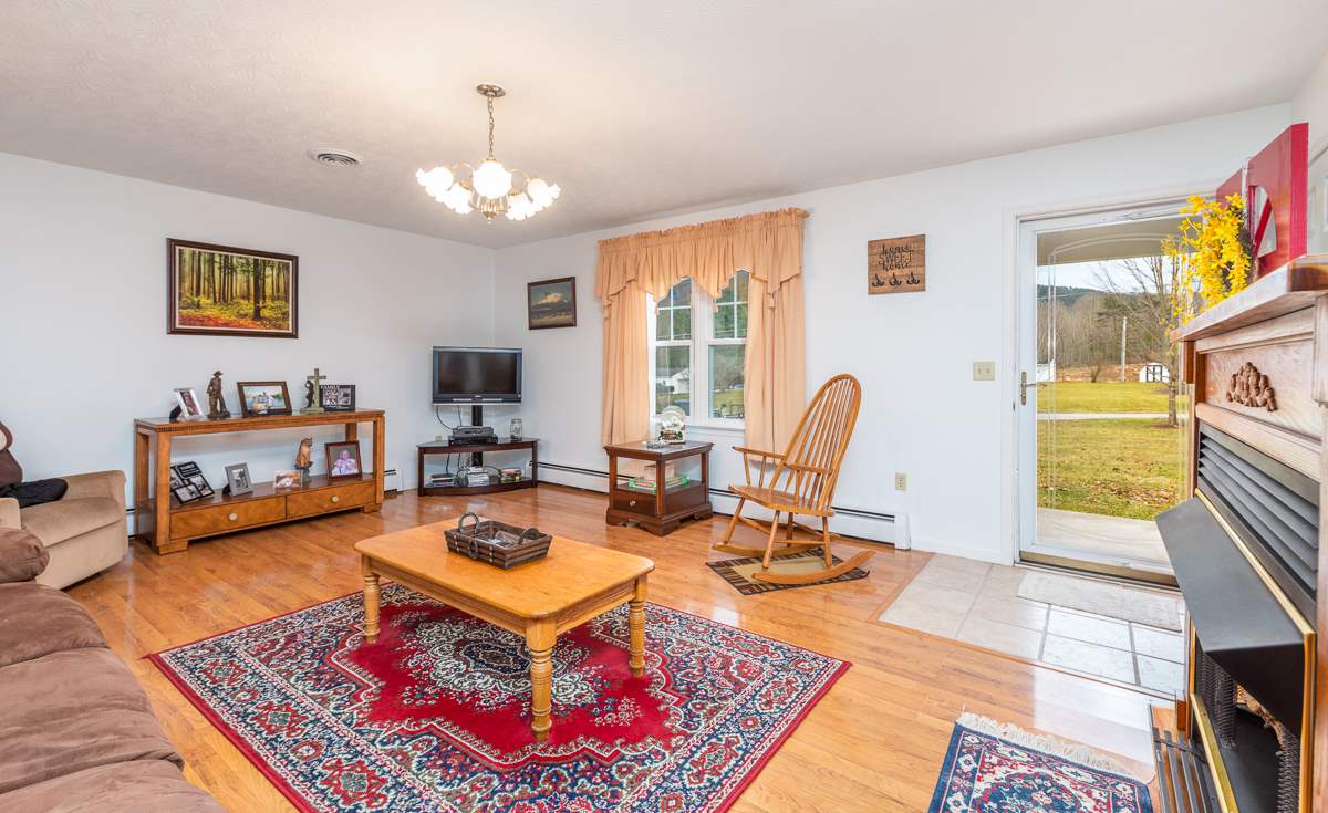 4233 Cold Springs Road Raphine, VA 24472 - Photo 18 of 50 a living room with furniture a fireplace and a flat screen tv