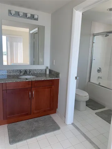 a bathroom with a shower a toilet and a sink