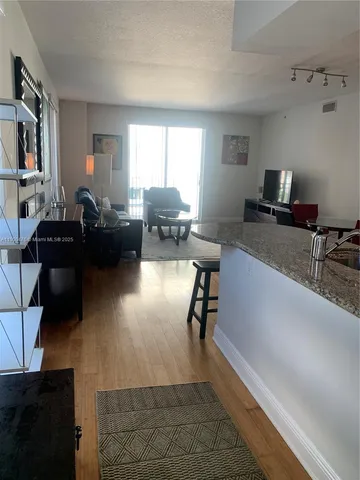 a kitchen with granite countertop a refrigerator stove top oven and sink