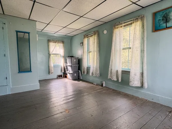 a view of a livingroom with furniture wooden floor and windows