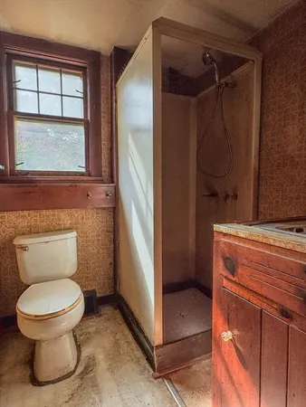 a bathroom with a toilet and a shower