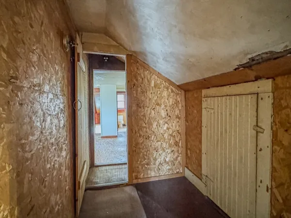a view of a hallway with wooden floor and a door