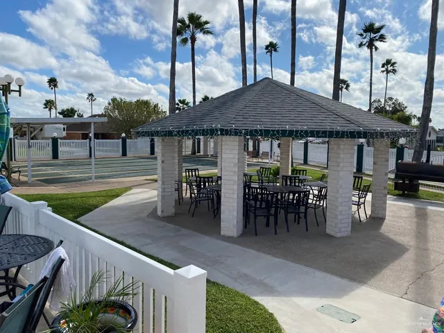 a view of a patio with dining table and chairs with wooden floor and fence