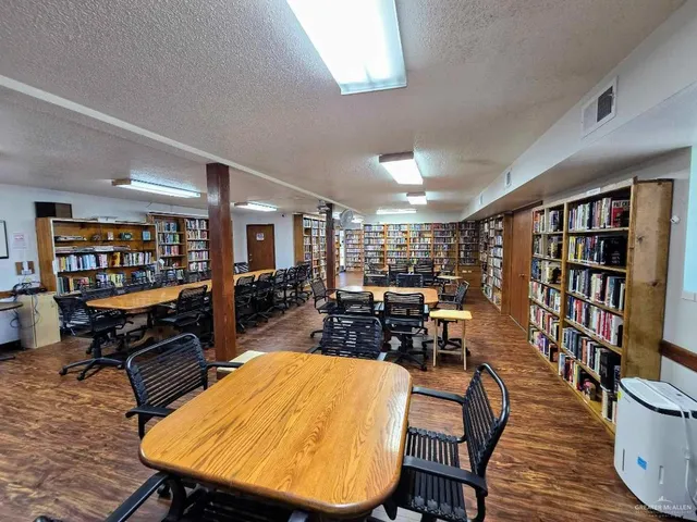 a living room with furniture a rug and a book shelf