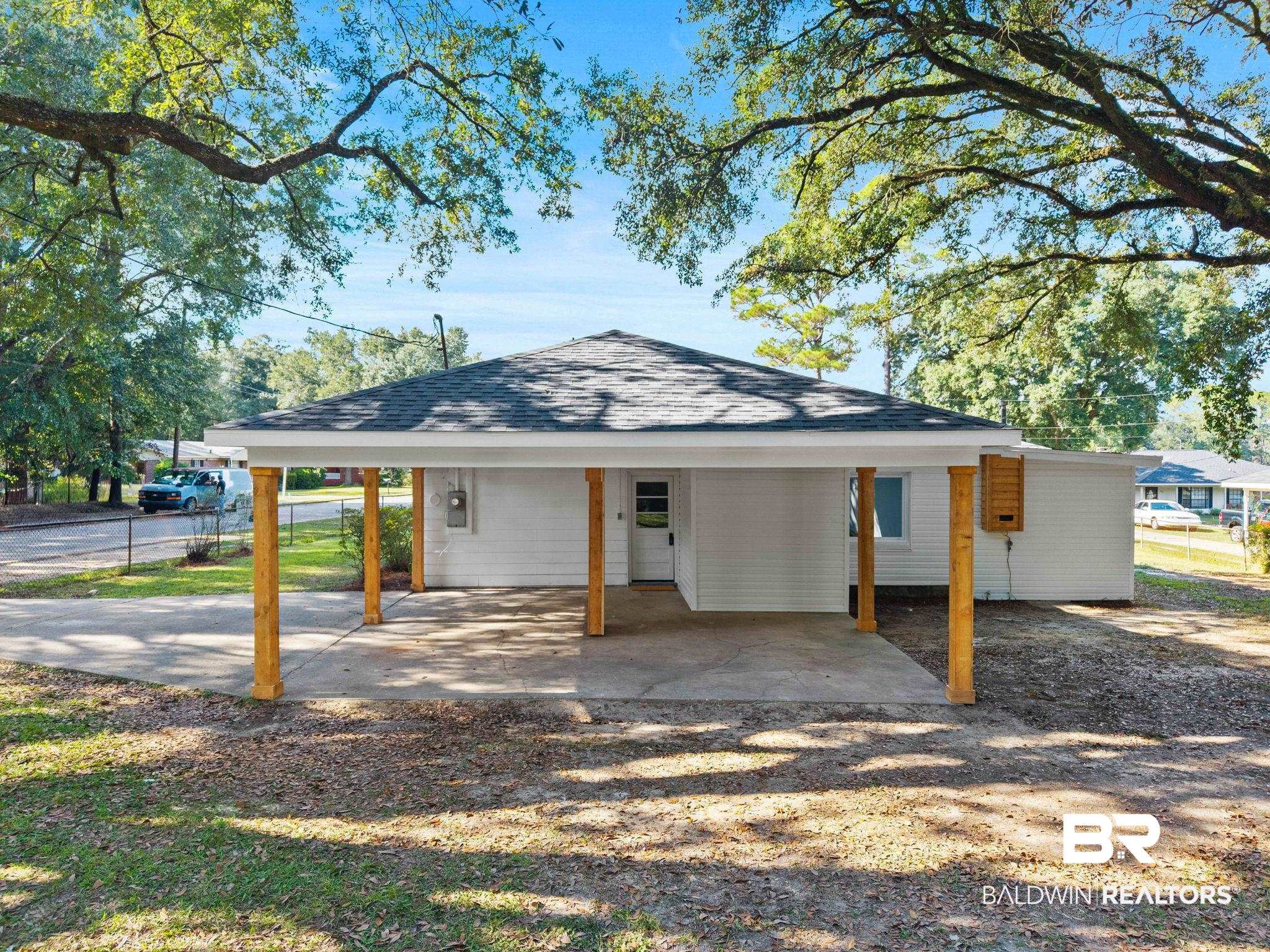 618 Pine Street Saraland, AL 36571 - Photo 32 of 41 View of front of property with a carport, a shingled roof, and a porch