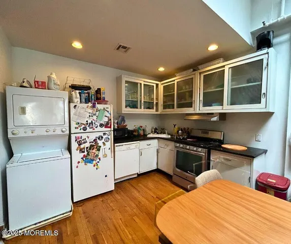 a kitchen with stainless steel appliances kitchen island granite countertop a refrigerator and a stove top oven