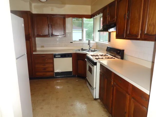 a kitchen with a sink stove top oven and cabinets