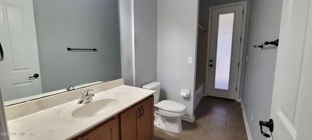 a bathroom with a toilet sink and mirror