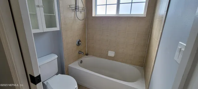 a bath room with a toilet and a tub