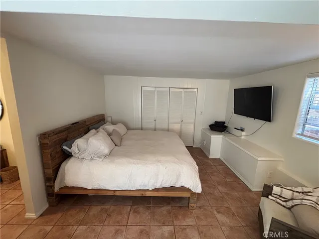a bedroom with a bed and a flat screen tv