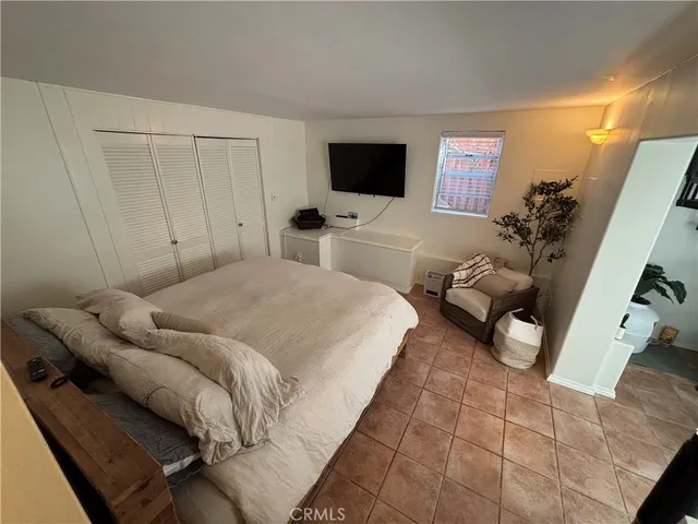 a bedroom with a bed and a flat screen tv